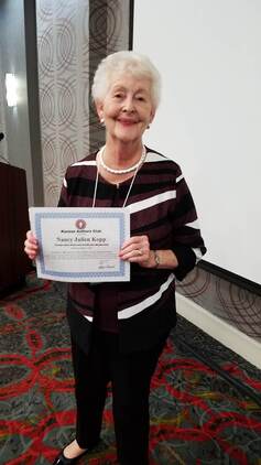 Image of Nancy Julien Kopp with 20 year membership certificate.